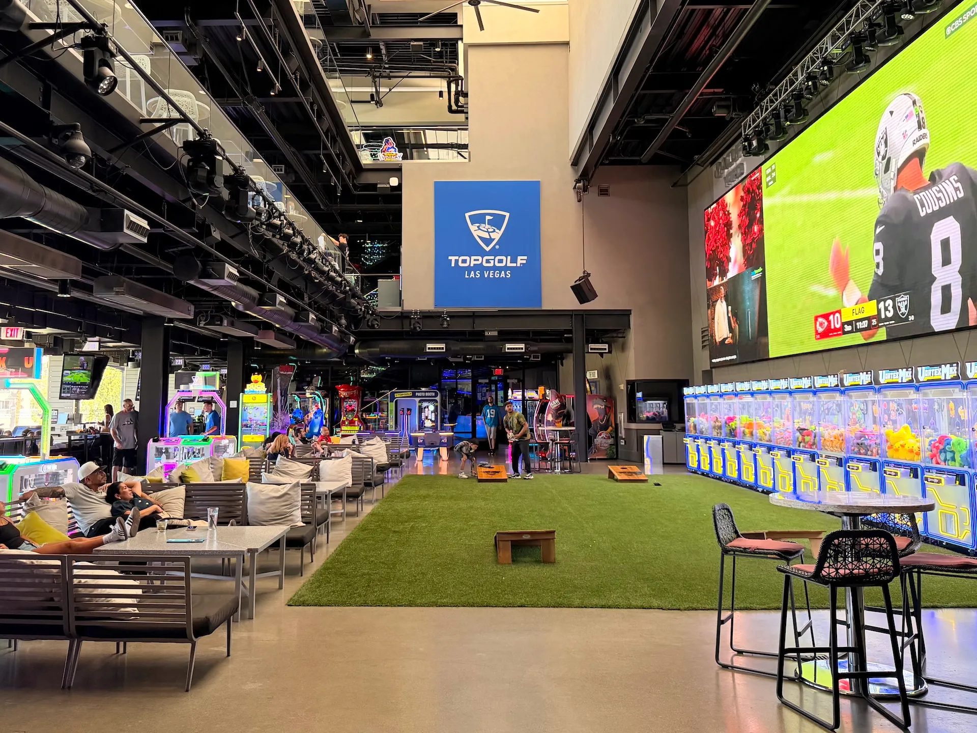 The Yard on Level 2 at Topgolf Las Vegas featuring newly added arcade cabinets and claw prize machines below the giant 48-foot sports screen